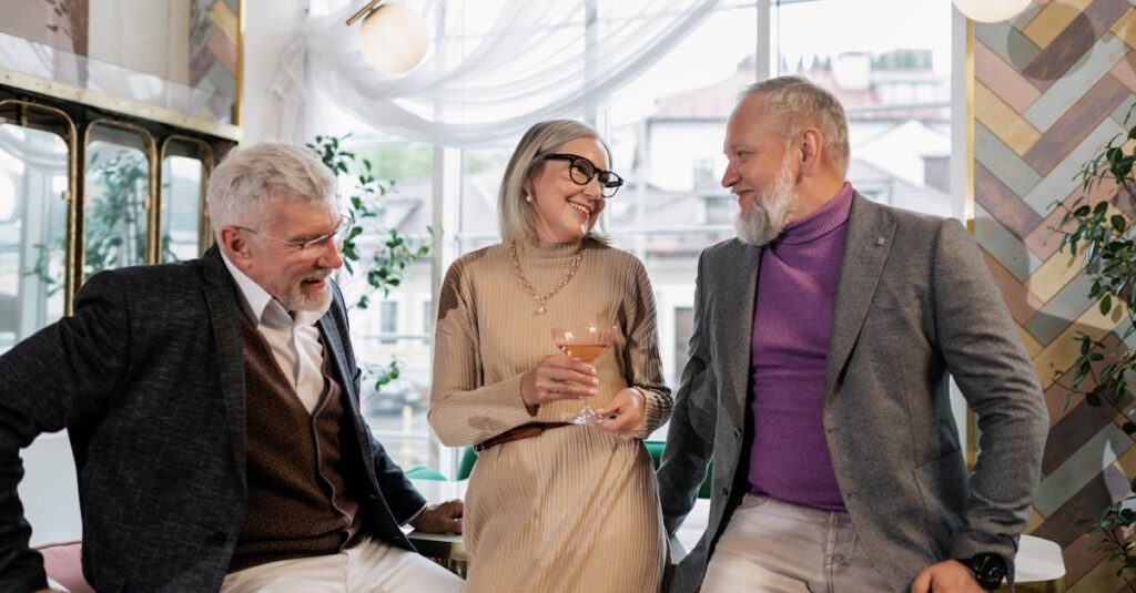 Three seniors bonding over drinks in a modern cafe setting, sharing laughter and joy.
